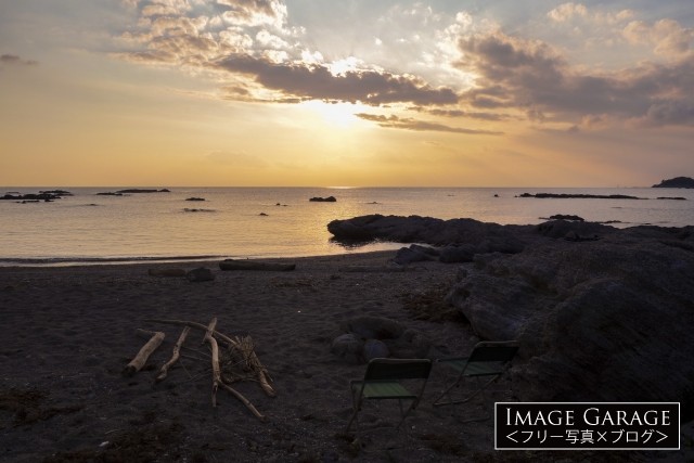 夕日を見ながら過ごす海岸のキャンプ風景のフリー写真素材（無料）