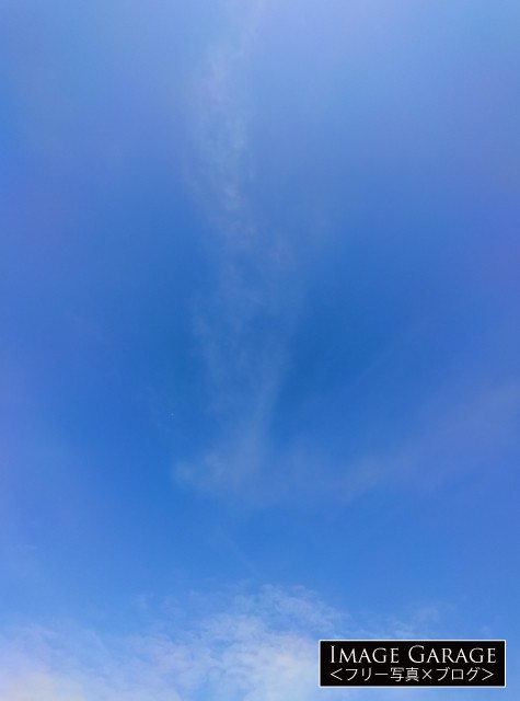 真ん中にうっすら雲のある青空（縦）のフリー画像