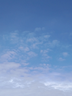 ポツポツした雲がある青空（縦位置）