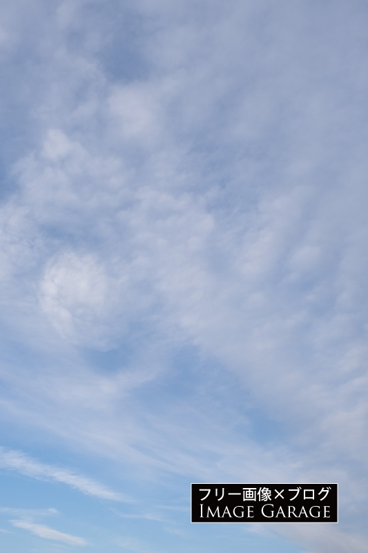 おへそみたいな雲がある青空（縦）のフリー写真素材（無料画像）
