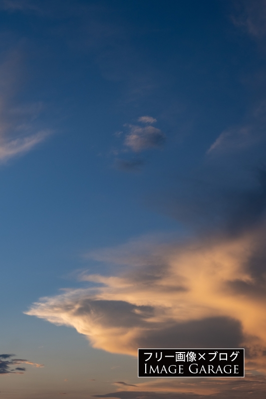 夕暮れ時の光を浴びた空と雲（縦）のフリー画像（無料写真素材）