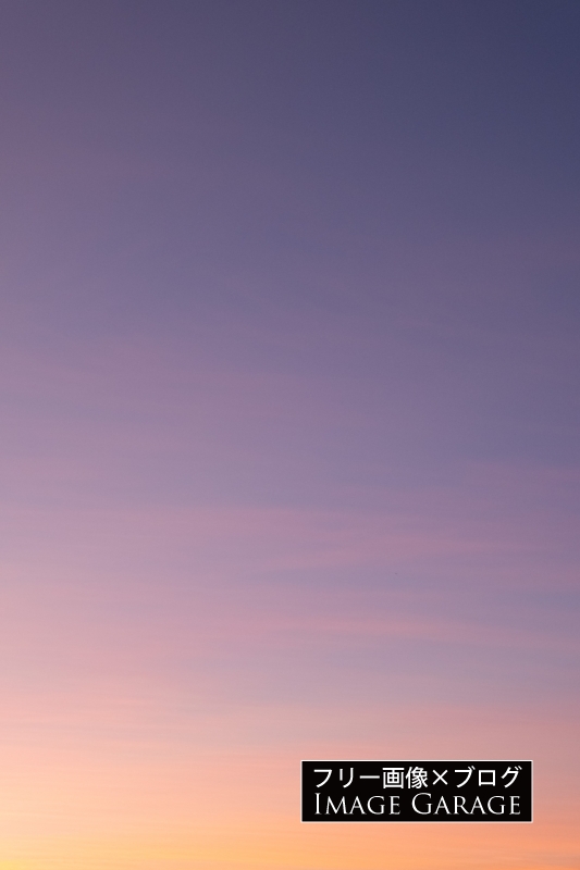 オレンジと紫の夕焼け空（縦）のフリー写真素材（無料画像）