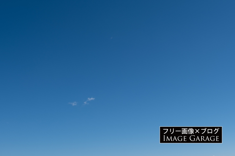 小さな雲がポツンとある快晴の空のフリー写真素材（無料画像）