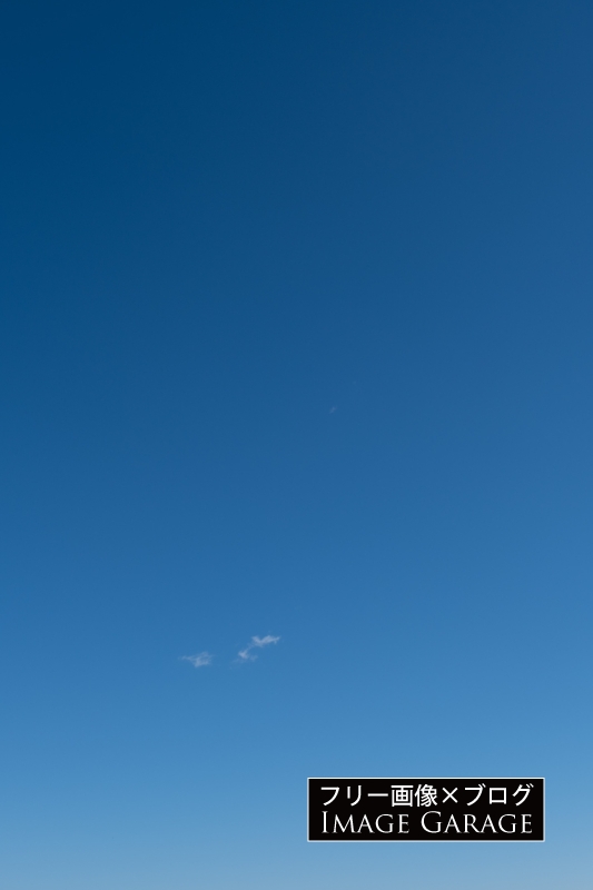 小さな雲がポツンとある快晴の空（縦）のフリー写真素材（無料画像）