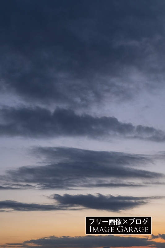 雲の浮く夕焼けの空（縦）のフリー写真素材（無料画像）