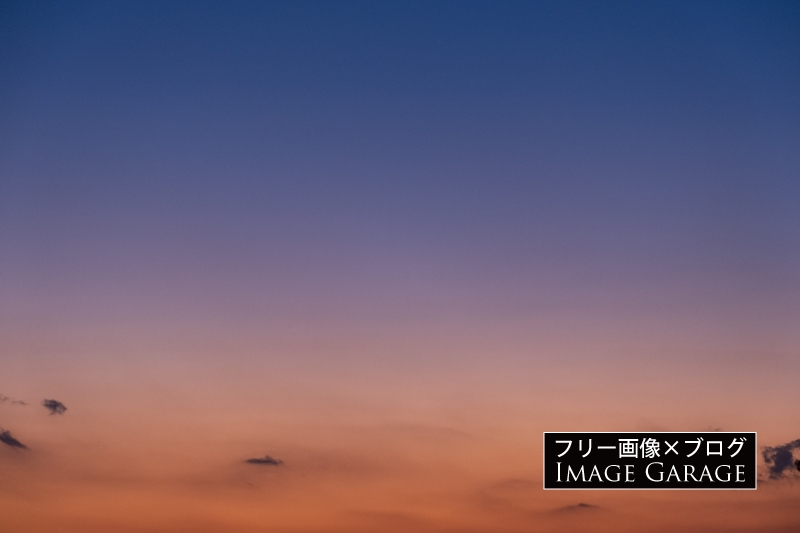 深い青とオレンジの夕焼け空のフリー写真素材（無料画像）