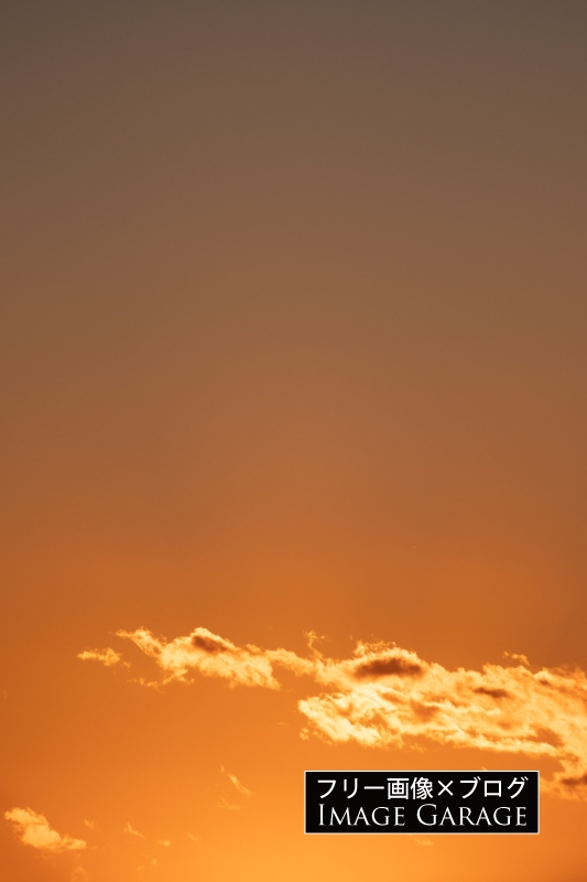 オレンジ色が美しい夕焼け空と雲（縦）のフリー写真素材（無料画像）