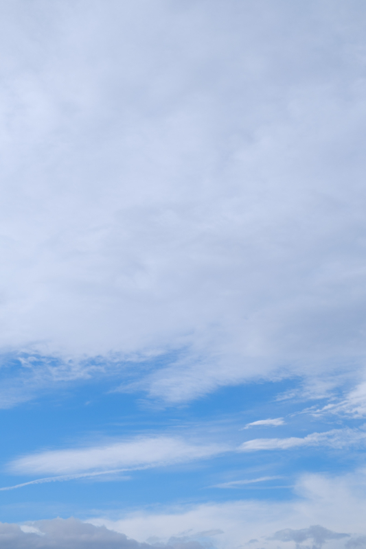 青空がのぞいている曇り空（縦位置）のフリー写真素材