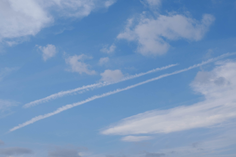 飛行機雲がある青空（横）のフリー写真素材